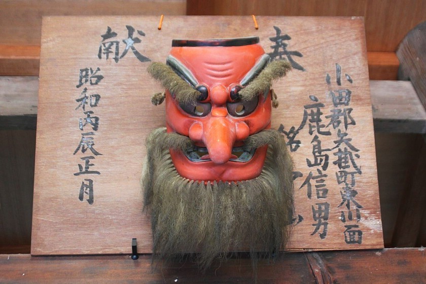 Foto tirada de uma máscara de tengu exposta em um templo no Japão